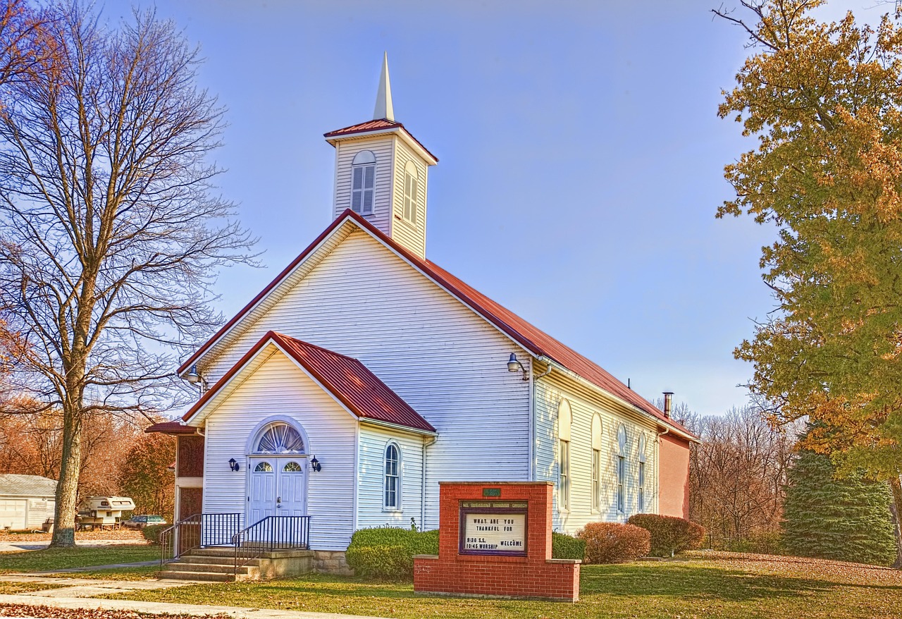 Image of a country church, red roof and white painted.